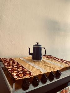 a tea kettle sitting on top of a table with chocolates at Casa no coração de Areia in Areia +19 photos