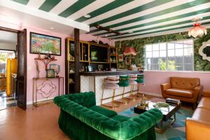 Una sala de estar con muebles verdes y un techo rayado. en Mid-Century Modern Home in Beautiful La Quinta, en La Quinta