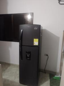 a black refrigerator in the corner of a room at Apto central 3 hab in Apartadó