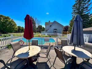 two tables and chairs with umbrellas on a patio at Beautiful tranquil centrally located condo in Collingwood