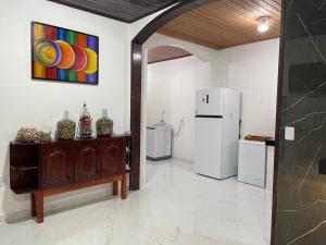 une pièce avec un réfrigérateur et une table avec des vases dans l'établissement Casa Relaxante, à Salinópolis
