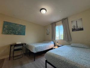 Una pequeña habitación con dos camas y una ventana. en Blue Private Room near BMO Stadium USC and K-Town, en Los Ángeles