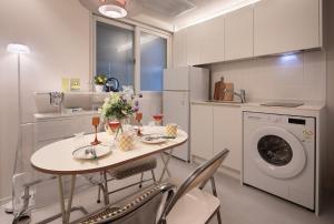 a kitchen with a table and a washing machine at Stay BUT SEONGSU in Seoul