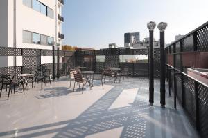a balcony with tables and chairs on a building at Stay BUT SEONGSU in Seoul
