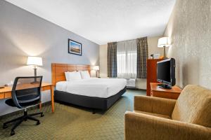 a hotel room with a bed and a desk and a tv at Quality Inn Dubuque on Hwy 20 in Dubuque