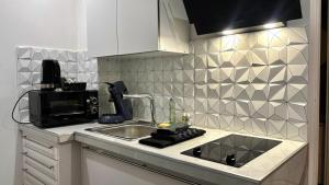 a kitchen with a sink and a microwave at Appartement t1 aiguebelle in Randens