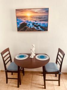 tavolo da pranzo con due sedie e un dipinto sul muro di Aquamarine a San Juan