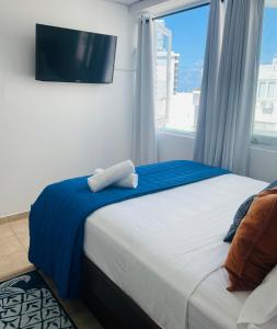 una camera da letto con un letto e una tv a parete di Aquamarine a San Juan