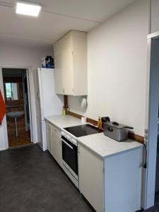 una cucina con mobili bianchi e un forno a piano cottura di Spacious Cosy Apartment a Søborg Altre 3 foto