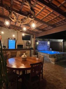 a dining room with a table and a swimming pool at Villas House in Pirenópolis +50 photos