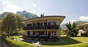 a large house with mountains in the background at Apartments in Pieve di Ledro - Ledrosee 22645 in Ledro
