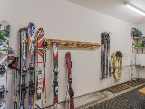 ein Haufen Skier und Snowboards hängen an einer Wand in der Unterkunft Krammer XL in Neukirchen am Großvenediger