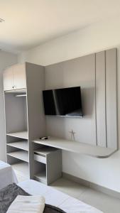 ein Schlafzimmer mit einem TV an einer weißen Wand in der Unterkunft Flat em Barra Grande com piscina in Barra Grande