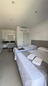 Drei Betten in einem großen Zimmer mit Ofen in der Unterkunft Flat em Barra Grande com piscina in Barra Grande