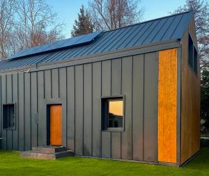 een metalen gebouw met oranje deuren en een dak bij Siedlisko Rawka in Doleck