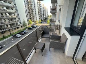 an apartment balcony with chairs and a view of a street at Hills pallady in Bucharest