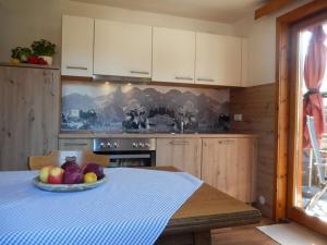 een keuken met een tafel met daarop een schaal fruit bij I in the Anton house in Obermaiselstein