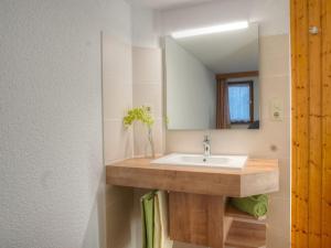 een badkamer met een wastafel en een spiegel bij I in the Anton house in Obermaiselstein +20 foto's