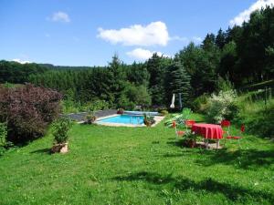 een tuin met een tafel en stoelen en een zwembad bij Haldenhäusle Black Forest in Oberschwärzenbach