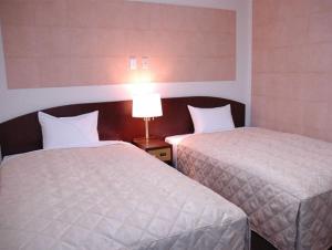 Postel nebo postele na pokoji v ubytování Tachikawa Urban Hotel