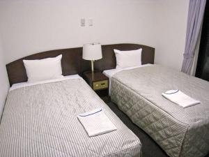Postel nebo postele na pokoji v ubytování Tachikawa Urban Hotel