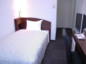 سرير أو أسرّة في غرفة في Tachikawa Urban Hotel