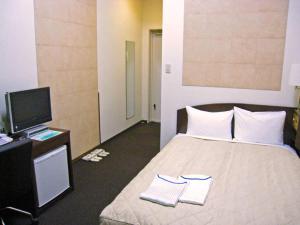 Postel nebo postele na pokoji v ubytování Tachikawa Urban Hotel