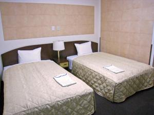 Postel nebo postele na pokoji v ubytování Tachikawa Urban Hotel