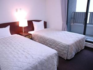 Postel nebo postele na pokoji v ubytování Tachikawa Urban Hotel + 6 fotografií