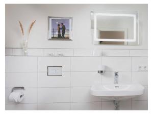 een witte badkamer met een wastafel en een spiegel bij Old Forester's Lodge Wildenthal - App 5 in Wildenthal +34 foto's