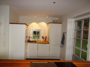 una cucina con mobili bianchi e una finestra di Object 77 Nieblum a Goting Altre 19 foto