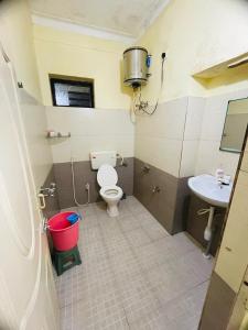 une petite salle de bain avec toilettes et lavabo dans l'établissement budget stay-mystique inn, à Ooty