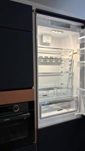 ein leerer Kühlschrank mit offener Tür und seiner Tür in der Unterkunft Luxueux t3 Aiguebelle in Randens