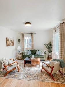 een woonkamer met een groene bank en stoelen bij Rose Park Cottage in Community Medical Center Heliport