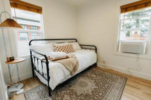 een slaapkamer met een bed en twee ramen bij Rose Park Cottage in Community Medical Center Heliport +19 foto's