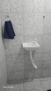 a bathroom with a white sink and a blue towel at Cantinho dos netos-suites próximo ao Sesc em Bertioga in Bertioga +9 photos