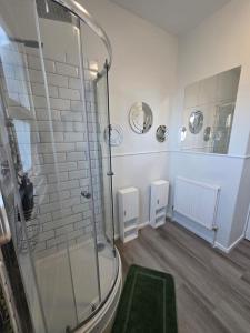 a bathroom with a shower and a green rug at Aura - 8ight Havens Folkestone in Folkestone