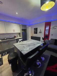 a kitchen with a table in the middle of a room at Aura - 8ight Havens Folkestone in Folkestone