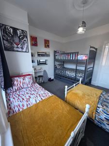 a bedroom with two beds and a desk and shelves at Aura - 8ight Havens Folkestone in Folkestone