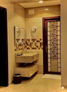 un bagno con lavandino e specchio di Quartz Executive - كوارتز التنفيذية a Abha