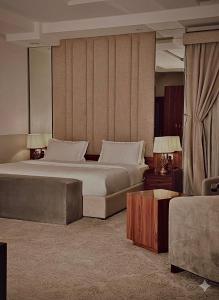 una camera d'albergo con un letto grande e un divano di Quartz Executive - كوارتز التنفيذية a Abha