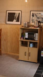 a room with wooden walls and a shelf with a microwave at El Jardin in Puerto Natales