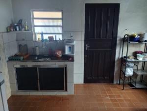 een keuken met een aanrecht en een deur bij Casa azul in Iguape