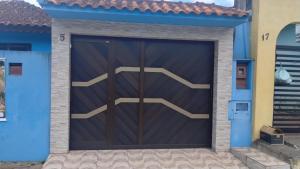 een houten garagedeur in een blauw huis bij Casa azul in Iguape