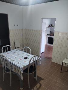 een eetkamer met een tafel en stoelen en een keuken bij Casa azul in Iguape