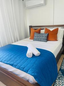 un letto con una coperta blu e cuscini arancioni di Aquamarine a San Juan Altre 4 foto