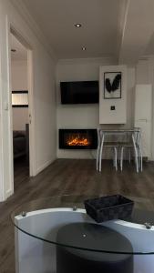 ein Wohnzimmer mit einem Glastisch und einem Kamin in der Unterkunft Spacieux T3 aiguebelle in Randens