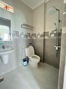 een badkamer met een toilet, een wastafel en een douche bij Vi-vu Hotel Quy Nhơn in Quy Nhon