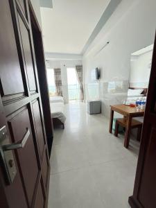 een woonkamer met een kamer met een tafel bij Vi-vu Hotel Quy Nhơn in Quy Nhon