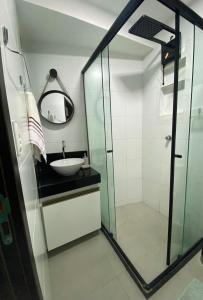 een badkamer met een wastafel en een glazen douche bij Sofisticado, aconchegante e moderno in João Pessoa